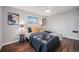 Cozy bedroom featuring wood floors, a ceiling fan, a sun-filled window and tasteful decor at 8626 W Utah Ave, Lakewood, CO 80232