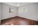 Bright bedroom featuring wood floors, a ceiling fan, and dual windows with backyard views at 8626 W Utah Ave, Lakewood, CO 80232