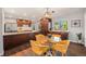 Open dining area featuring a modern light fixture and yellow chairs, adjacent to the updated kitchen at 8626 W Utah Ave, Lakewood, CO 80232