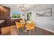 Cozy dining area with a round glass table, modern yellow chairs, and a view of the backyard at 8626 W Utah Ave, Lakewood, CO 80232