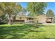Charming one-story home featuring a well-maintained lawn, mature trees, and an inviting front porch at 8626 W Utah Ave, Lakewood, CO 80232