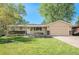Inviting one-story home showcasing lush green grass, mature shade trees, and an attached garage at 8626 W Utah Ave, Lakewood, CO 80232