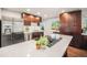 Spacious kitchen with stainless steel appliances, an island cooktop, and dark wood cabinets at 8626 W Utah Ave, Lakewood, CO 80232