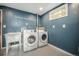 Modern laundry room with utility sink and front loading washer and dryer at 8626 W Utah Ave, Lakewood, CO 80232