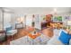 Open-concept living area featuring hardwood floors, neutral decor, and views of the dining room at 8626 W Utah Ave, Lakewood, CO 80232