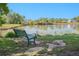 Relaxing view of the pond from a bench surrounded by green grass and trees on a sunny day at 8626 W Utah Ave, Lakewood, CO 80232