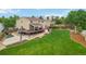 Aerial view of house with big backyard, deck, concrete patio, and lush green lawn at 10870 Crestone Needles Dr, Parker, CO 80138