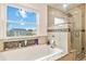 A luxurious bath featuring a large window, soaking tub and tiled glass shower at 10870 Crestone Needles Dr, Parker, CO 80138