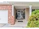 Inviting front entryway with a secure screen door and traditional brick pillar at 10870 Crestone Needles Dr, Parker, CO 80138