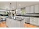 Bright kitchen featuring white cabinetry, stainless steel appliances, and an island with a gray quartz countertop at 10870 Crestone Needles Dr, Parker, CO 80138