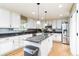 A spacious kitchen with white cabinetry, stainless steel appliances, and a gray quartz countertop island at 10870 Crestone Needles Dr, Parker, CO 80138