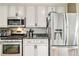 A well-equipped kitchen with stainless steel appliances and white cabinetry at 10870 Crestone Needles Dr, Parker, CO 80138