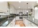 A lovely kitchen with white cabinets, stainless steel appliances, and a gray quartz countertop island at 10870 Crestone Needles Dr, Parker, CO 80138