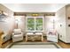 Cozy living room area enhanced by a large window, wood floors and comfortable seating at 10870 Crestone Needles Dr, Parker, CO 80138