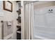 Cozy bathroom features modern fixtures, open shelving, and a shower with neutral shower curtain at 2923 W Bryant Cir, Littleton, CO 80120