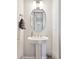 Stylish powder room featuring a pedestal sink and an oval mirror at 6970 E Lake Dr, Centennial, CO 80111