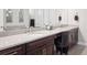 Double sink bathroom vanity with stone countertops, dark wood cabinets, and decorative mirrors at 6970 E Lake Dr, Centennial, CO 80111