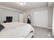 Spacious bedroom featuring a large bed, sliding closet doors, and neutral carpeting at 6970 E Lake Dr, Centennial, CO 80111