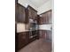 Kitchen with stainless steel double ovens, dark wood cabinets, granite countertops and tile backsplash at 6970 E Lake Dr, Centennial, CO 80111