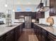 Modern kitchen features stainless steel appliances, dark wood cabinetry, and granite countertops at 6970 E Lake Dr, Centennial, CO 80111