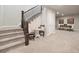 Carpeted staircase with dark wood railings leads to a dining area with a table and chairs at 6970 E Lake Dr, Centennial, CO 80111