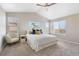 Bright bedroom featuring neutral walls, large windows with blinds, and a ceiling fan at 13742 Valentia St, Thornton, CO 80602