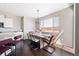 A dining room with an industrial-style chandelier, seating for six, and large window for natural light at 13742 Valentia St, Thornton, CO 80602