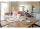 Dining room highlighting a rustic table setting, modern chairs, and an open flow to the living spaces at 13742 Valentia St, Thornton, CO 80602