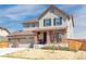 Charming two-story home with a covered porch, landscaped yard, two-car garage, and inviting curb appeal at 13742 Valentia St, Thornton, CO 80602