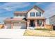 Charming two-story home featuring a three-car garage, brick accents, and a cozy front porch perfect for relaxing at 13742 Valentia St, Thornton, CO 80602