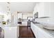 Bright kitchen showcases white cabinetry, granite countertops, stainless steel appliances, and dark hardwood floors at 13742 Valentia St, Thornton, CO 80602