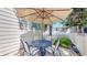 Back patio with a table, chairs and shade under an umbrella providing a nice entertaining area at 10532 Madison St, Thornton, CO 80233