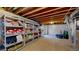View of unfinished basement with open joists and shelving for ample storage at 10532 Madison St, Thornton, CO 80233