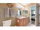 Bathroom with neutral earth tones featuring a vanity mirror, sink, and toilet at 10532 Madison St, Thornton, CO 80233