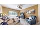 Bright bedroom featuring a ceiling fan, large window, and dark wood furniture at 10532 Madison St, Thornton, CO 80233