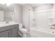 Bright bathroom with a white shower-tub combo, light gray vanity and a white toilet at 3338 Ireland Moss St, Castle Rock, CO 80109