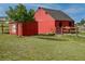 A well-maintained red barn and storage shed on a spacious grassy field at 2501 Remington Rd, Elizabeth, CO 80107