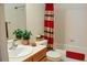 Bathroom with a sink, toilet, and shower with a red striped shower curtain at 2501 Remington Rd, Elizabeth, CO 80107