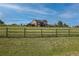 Two-story home featuring a deck, visible through a wooden fence, surrounded by a lush green lawn at 2501 Remington Rd, Elizabeth, CO 80107
