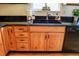 Close-up of the kitchen sink with dark granite countertops, light wood cabinets, and stainless steel faucet at 2501 Remington Rd, Elizabeth, CO 80107