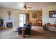 Bright living room featuring a fireplace, ceiling fan, neutral carpet, and sliding glass door access to the backyard at 2501 Remington Rd, Elizabeth, CO 80107