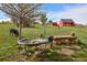 Lush backyard featuring a bird bath, a dog, and a rustic wooden bench, with a barn in the distance at 2501 Remington Rd, Elizabeth, CO 80107