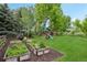 Large backyard with garden beds, a play structure, and plenty of green space at 7760 Crestview Ln, Niwot, CO 80504