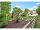 Expansive backyard featuring raised garden beds, a wooden playset, beautiful landscaping, and a rustic wooden fence at 7760 Crestview Ln, Niwot, CO 80504