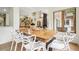 Bright dining room with view into the kitchen and living room featuring white chairs and wood table at 7760 Crestview Ln, Niwot, CO 80504