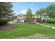 Expansive front lawn with a charming two-story home featuring a tile roof and mature trees at 7760 Crestview Ln, Niwot, CO 80504