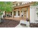 Inviting front porch with a decorative wooden door, stone steps, and seating area at 7760 Crestview Ln, Niwot, CO 80504