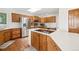 Bright kitchen with wood cabinetry, stainless steel appliances, tile floors, and a cooktop on a white island at 7760 Crestview Ln, Niwot, CO 80504