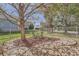 Charming backyard view featuring a seating area under a tree and a fence, offering a peaceful retreat at 18971 E Pinewood Dr, Aurora, CO 80016