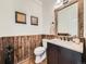A rustic-styled powder bathroom with unique wood paneling, framed mirror and modern fixtures at 18971 E Pinewood Dr, Aurora, CO 80016